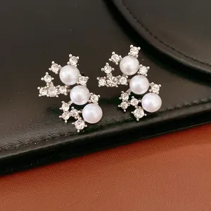 Vue détaillée de boucles d'oreilles élégantes en argent avec perles et strass brillants.