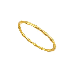 Vista detallada de un brazalete de acero inoxidable dorado con diseño de bambú pulido