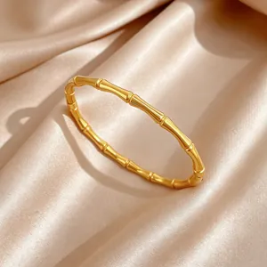 Vista detallada de una pulsera de acero de titanio dorado con diseño de bambú.