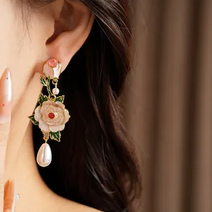 Exquisite vintage rose flower earrings with a pearl drop shown on a model's ear