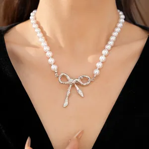 Primo piano di un'elegante collana di perle con un ciondolo a fiocco d'argento testurizzato