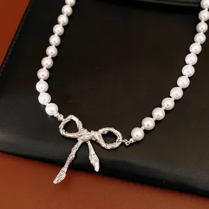 Primo piano di elegante collana di perle con ciondolo a fiocco d'argento
