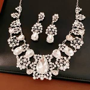 Vue détaillée d'un élégant ensemble de bijoux argentés avec fleurs de cristal et gouttes