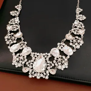 Détail macro d'un collier argenté élégant avec des strass étincelants en forme de goutte