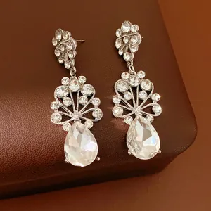 Détail rapproché exquis de boucles d'oreilles style palais avec cristaux gouttes de rosée