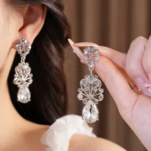 Détail des boucles d'oreilles goutte de fleur en cristal au style palais élégant.
