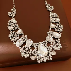 Détail d'un collier élégant argenté avec de gros cristaux clairs et des motifs floraux