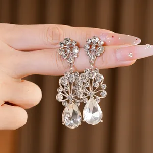 Vue macro d'élégantes boucles d'oreilles fleuries en strass avec cristal en goutte d'eau