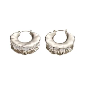 Exquisite gold-toned textured hoop earrings with embedded white pearls on white background