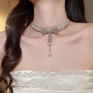 Elegant double-layered pearl choker necklace with a sparkling rhinestone bow and tassel