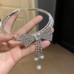 Detailed view of elegant silver rhinestone bow-knot choker with pearl tassel drops
