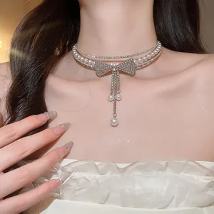 Close-up of a sparkling bow tassel pearl choker necklace worn by an elegant model.