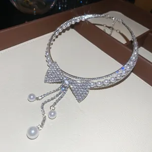 Close-up of sparkling rhinestone bow and pearl tassel on a luxury choker necklace