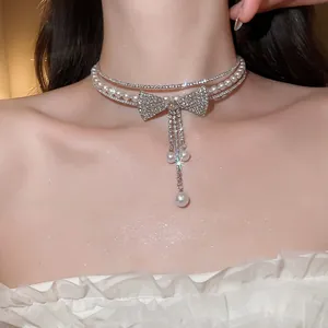 Detailed view of a sparkling rhinestone bow tassel pearl choker necklace on neck