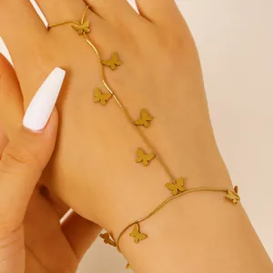 Detail of a gold-plated stainless steel butterfly slave bracelet on a woman's hand.