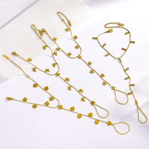 Detail view of gold stainless steel hand chain bracelets with star, heart and butterfly charms.