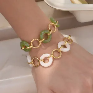 Detail of elegant green and white resin ring bracelets with gold-tone stainless steel links