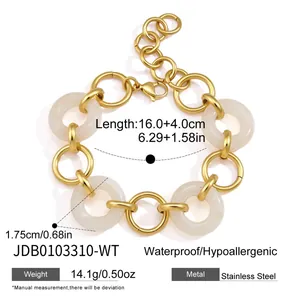 Close-up of gold-plated stainless steel bracelet featuring chunky off-white resin rings