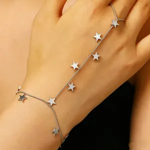 Close-up of stainless steel star charm hand harness bracelet on wrist and finger