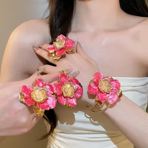 Primo piano di un set di bracciale e anelli in smalto floreale rosa su una modella