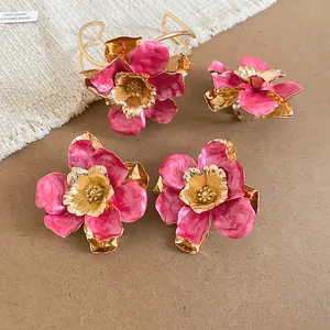 Dettaglio del set di gioielli floreali in smalto rosa e oro con bracciale e orecchini