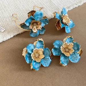 Vista dettagliata del set di gioielli con fiori smaltati blu e accenti dorati