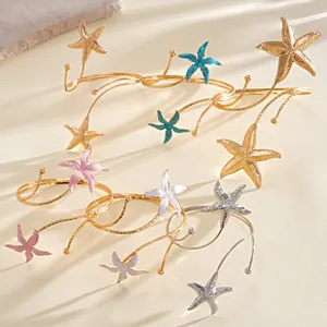 Detail van veelkleurige zeester-armbanden in goud en zilver met emaille afwerking.
