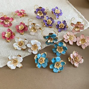 Dettaglio di parure di gioielli a fiore in smalto colorato con anelli e bracciali