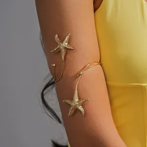 Close-up van een gouden metalen zeester open armring voor strandvakantie stijl.