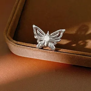 Elegant silver butterfly necklace with sparkling zircon, set on a brown jewelry tray.