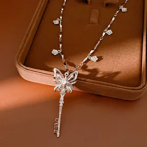 Detailed macro view of silver butterfly key pendant necklace with zircon flower charms.