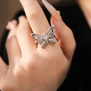 Macro detail view of an elegant silver butterfly ring featuring a sparkling zircon center