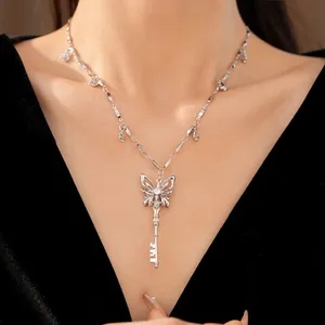 Close-up of elegant silver butterfly key necklace with sparkling zircon on a model