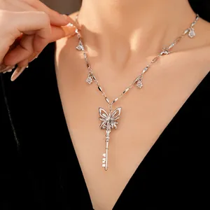 Detail of elegant silver butterfly key necklace with flower zircon charms on model