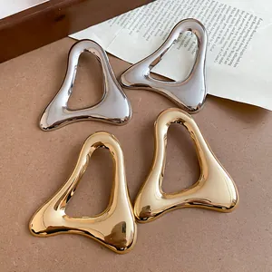 Detail showing the polished finish and hollow organic triangle shape of these retro earrings