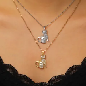 Nahaufnahme von geschichteten Gold- und Silber-Katzenanhängern mit Zirkonia-Schmetterling