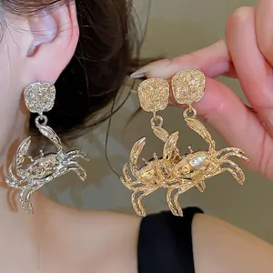 Exaggerated gold and silver crab stud earrings with a unique nautical ocean theme design