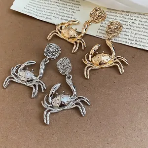 Ocean-style gold and silver crab-shaped drop earrings with a vintage metallic finish.