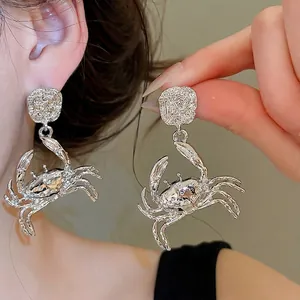 Fashionable oversized silver crab stud earrings with sparkling crystals in ocean style.