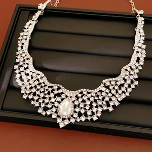 Elegant silver-toned bridal necklace featuring intricate rhinestone patterns and teardrop crystal