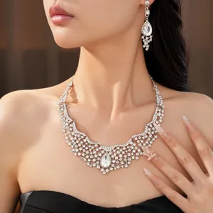 Close-up of elegant crystal teardrop necklace and earring set worn by a model