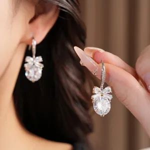 Gros plan détaillé de boucles d'oreilles nœud en zircon avec pierre ronde scintillante