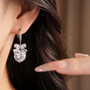 Gros plan détaillé sur des boucles d'oreilles nœud en zircon portées par un mannequin