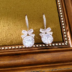 Détail macro de boucles d'oreilles nœud en zircon sur un cadre en velours olive vintage