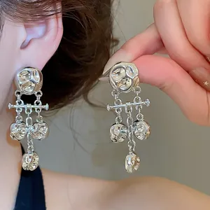 Detailed view of silver metallic wrinkled tassel earrings with vintage luxury aesthetic