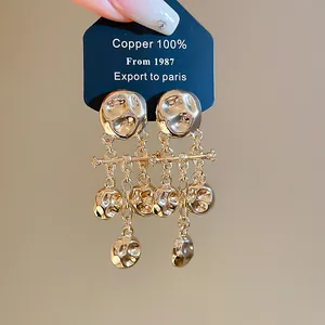 Close-up detail shot of vintage style hammered gold metal tassel earrings for women