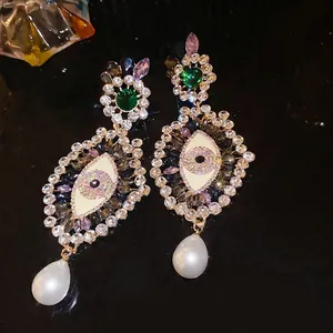 French vintage earrings featuring a rhinestone eye motif and elegant pearl drops.