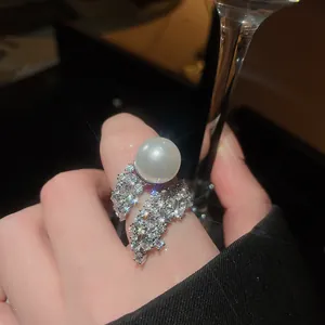 Close-up of an elegant ring featuring a large white pearl and sparkling zircon stones