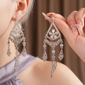 Silver-plated rhinestone earrings with flower tassel design shown on an Asian model's ear