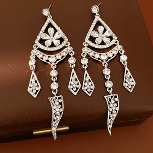 Close-up of elegant silver tassel earrings with sparkling rhinestones and flower motif
